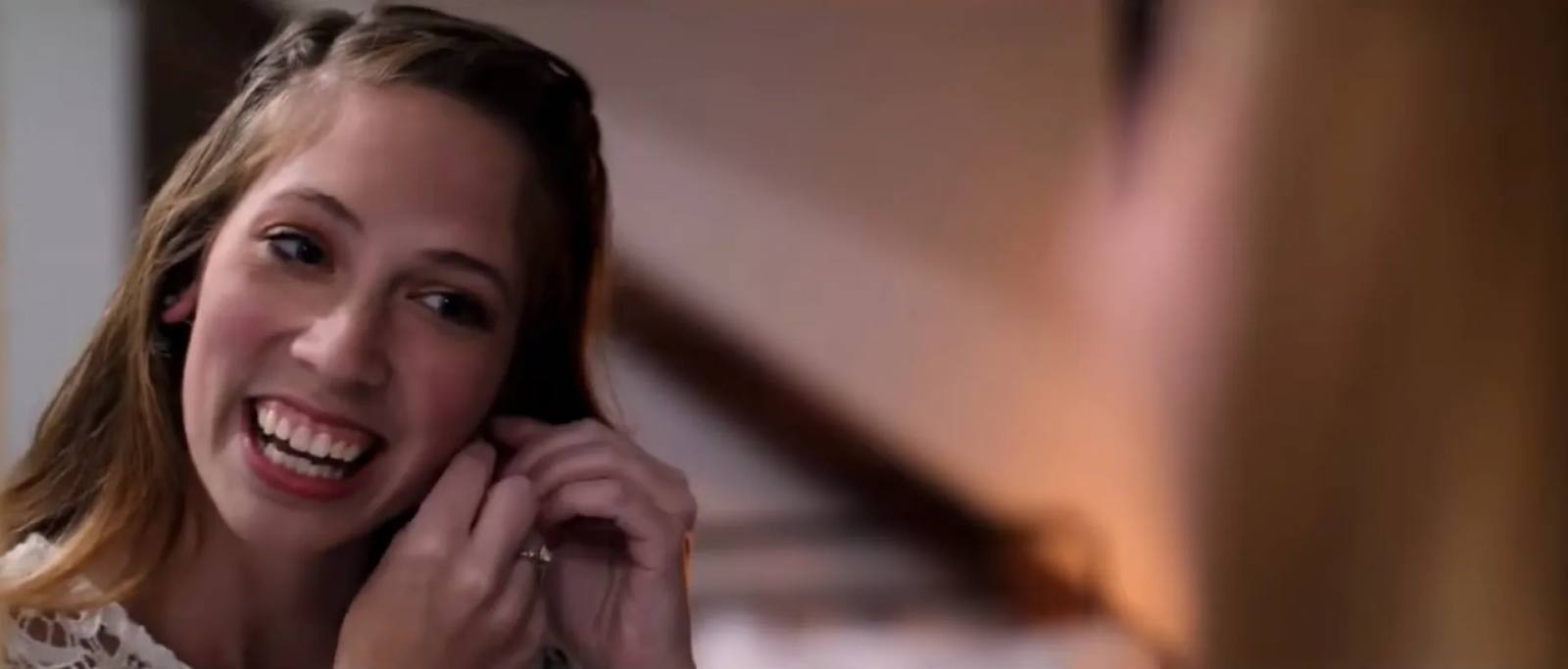 A picture of a beautiful woman putting earrings onto her ears